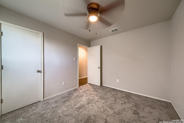 unfurnished bedroom with a ceiling fan, carpet, visible vents, and baseboards