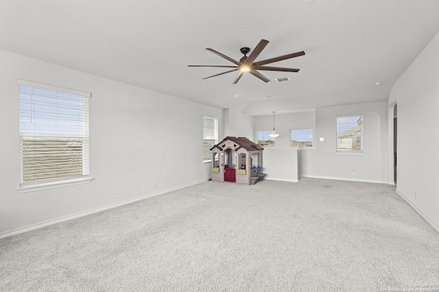 empty room featuring ceiling fan, carpet flooring, visible vents, and baseboards