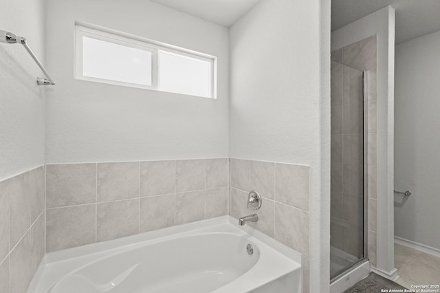 bathroom with a shower stall and a bath