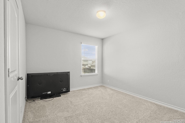 unfurnished bedroom featuring carpet, a textured ceiling, and baseboards