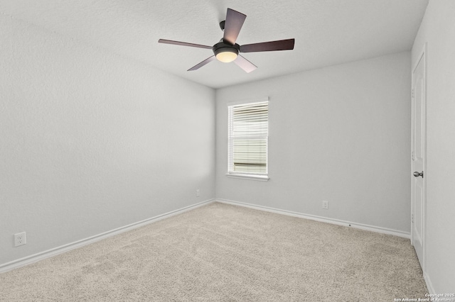 carpeted empty room featuring baseboards and a ceiling fan