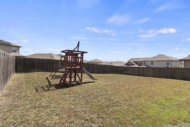 view of yard with a fenced backyard and a playground