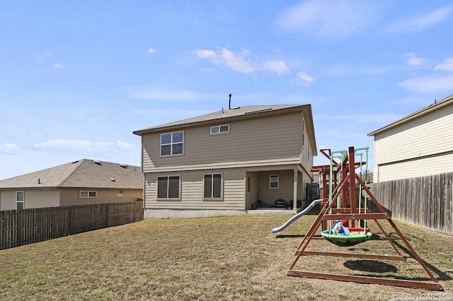 rear view of house with a playground, a yard, and a fenced backyard