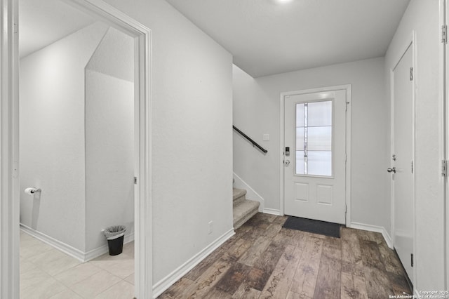 entryway featuring baseboards, stairway, and wood finished floors