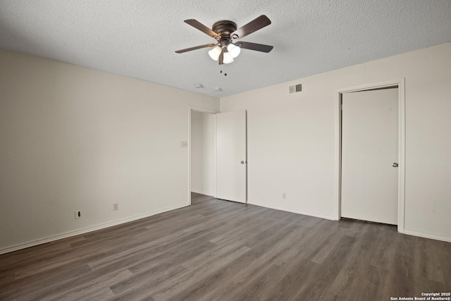 unfurnished bedroom featuring baseboards, a textured ceiling, visible vents, and wood finished floors