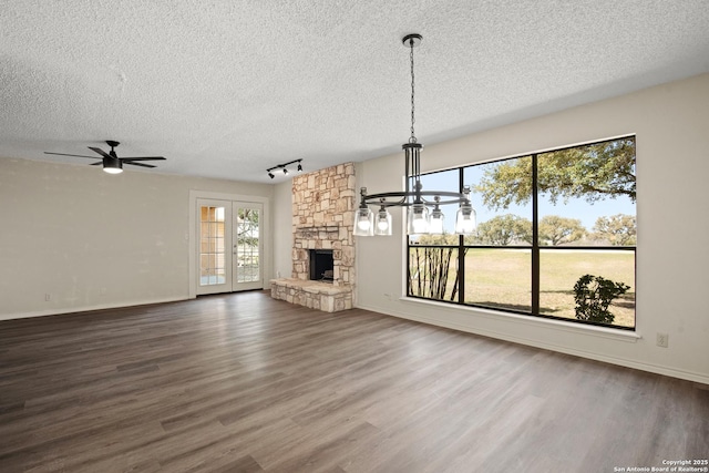 unfurnished living room with a textured ceiling, a fireplace, and wood finished floors