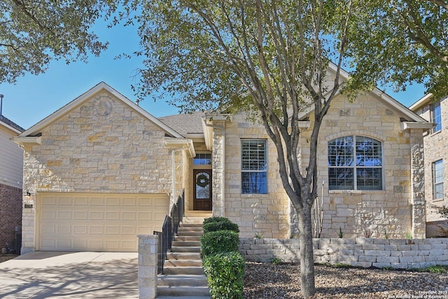 view of front of home with a garage, stone siding, driveway, and a shingled roof