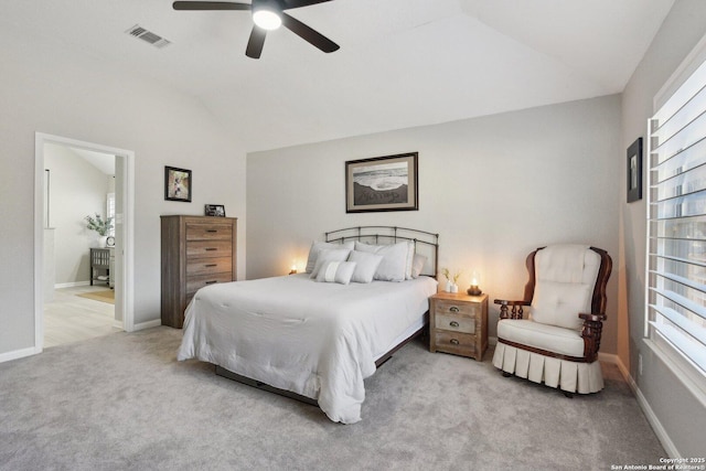 carpeted bedroom with lofted ceiling, connected bathroom, visible vents, and baseboards