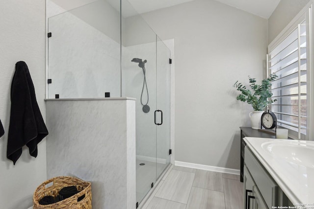 full bathroom featuring baseboards, a shower stall, and vanity