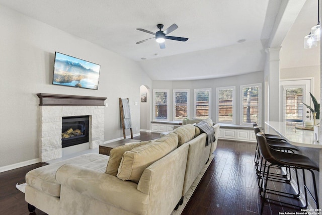 living room with lofted ceiling, dark wood-style floors, decorative columns, and a fireplace