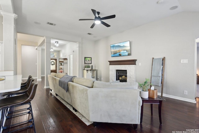 living room featuring dark wood-style floors, visible vents, and ornate columns