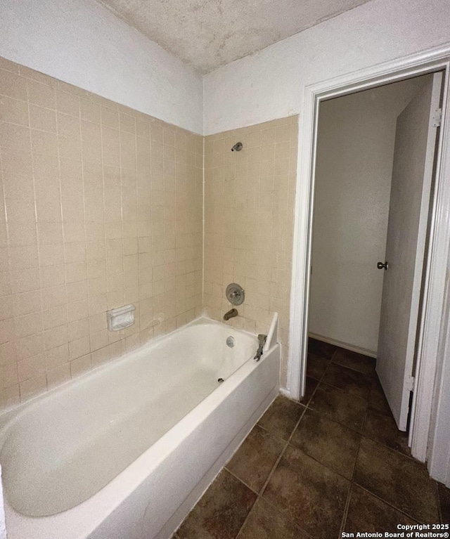 full bathroom with a textured ceiling, shower / bathing tub combination, and tile patterned flooring