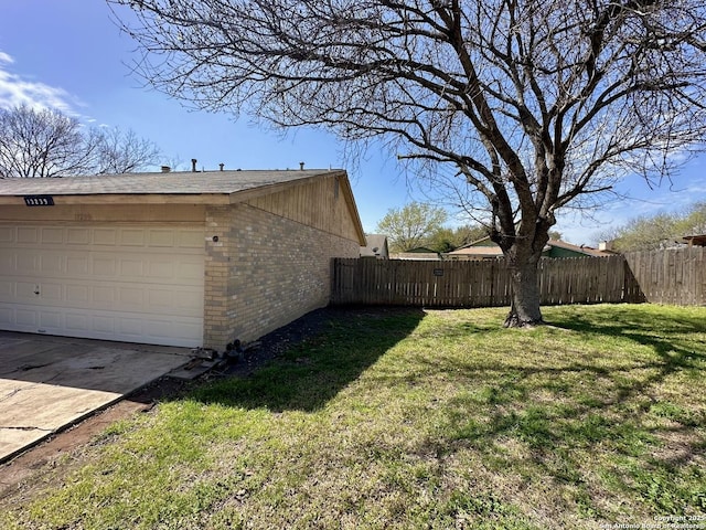 view of home's exterior with a garage, a yard, fence, and brick siding