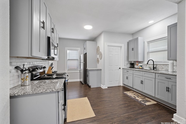 kitchen with dark wood-style flooring, plenty of natural light, stainless steel appliances, and a sink