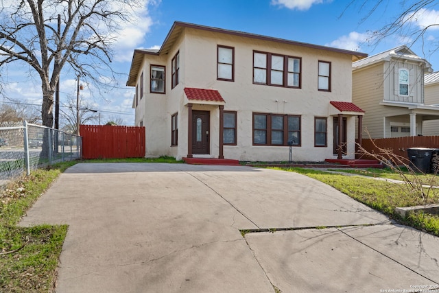 view of front facade featuring stucco siding and fence