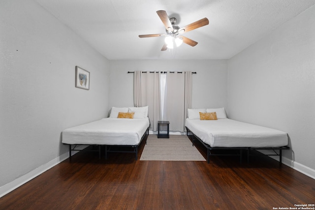 bedroom featuring ceiling fan, baseboards, and wood finished floors