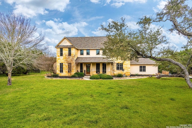 view of front of property featuring a front yard, covered porch, stone siding, and stucco siding