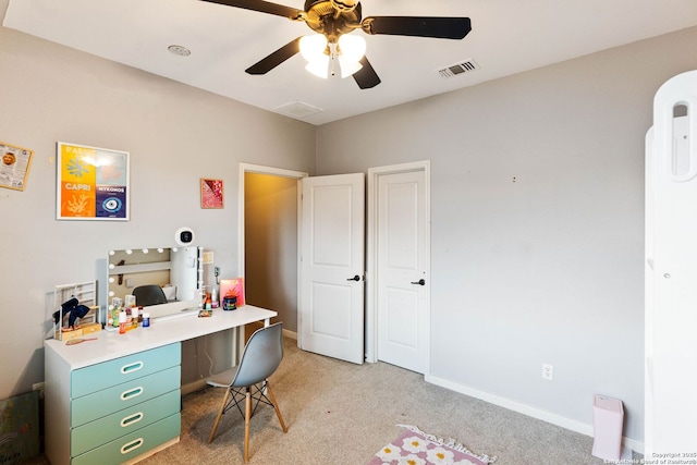 office area featuring visible vents, light carpet, baseboards, and ceiling fan
