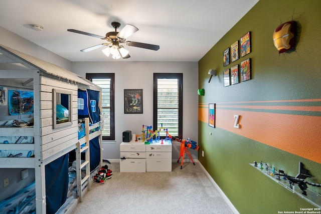 carpeted bedroom with a ceiling fan and baseboards