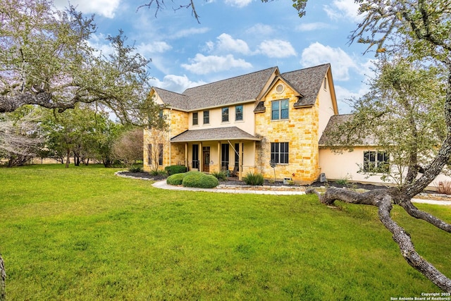 view of front of property with stucco siding, stone siding, covered porch, and a front yard