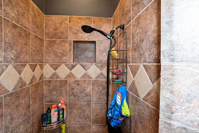 interior details featuring a tile shower