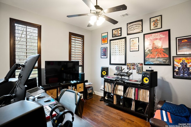 home office featuring visible vents, baseboards, ceiling fan, and wood finished floors