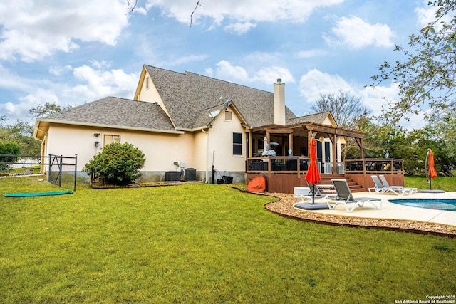 back of house featuring stucco siding, a patio, a yard, and a pergola