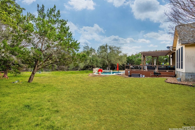 view of yard featuring a wooden deck, an outdoor pool, and a pergola