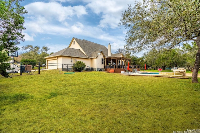 back of house featuring stucco siding, a lawn, fence, cooling unit, and a garage