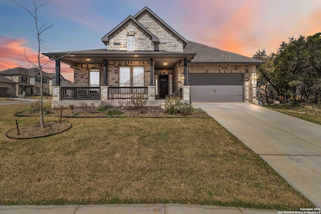 view of front of home with driveway, a porch, a yard, a garage, and brick siding