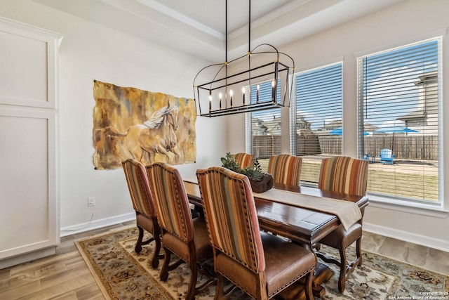 dining room featuring baseboards, a chandelier, and light wood finished floors