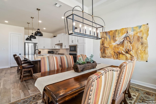 dining area featuring baseboards, visible vents, wood tiled floor, recessed lighting, and a notable chandelier