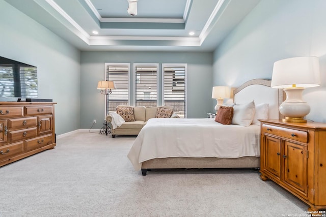 bedroom with light colored carpet, a raised ceiling, baseboards, and multiple windows