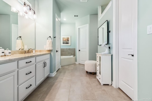 bathroom featuring tile patterned floors, a bath, and vanity