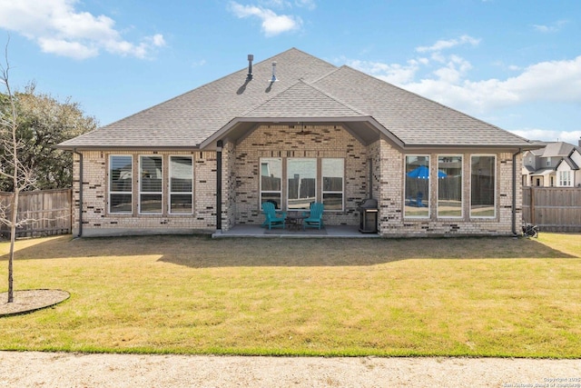 back of house featuring a yard, brick siding, a fenced backyard, and a patio area