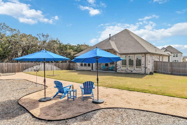 view of playground with a lawn, a fenced backyard, and a patio area