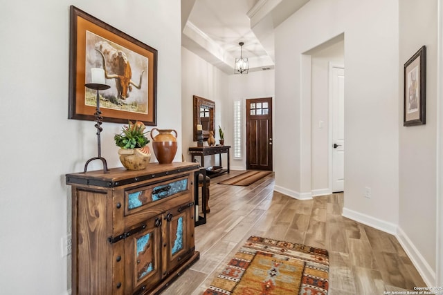 foyer with an inviting chandelier, baseboards, and light wood-style floors