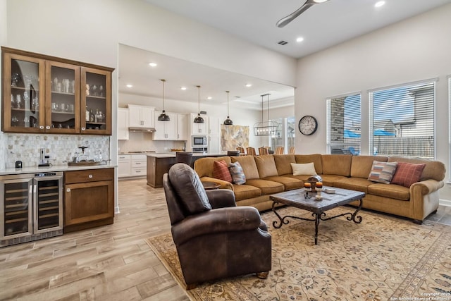 living room featuring visible vents, beverage cooler, recessed lighting, light wood-style floors, and indoor bar