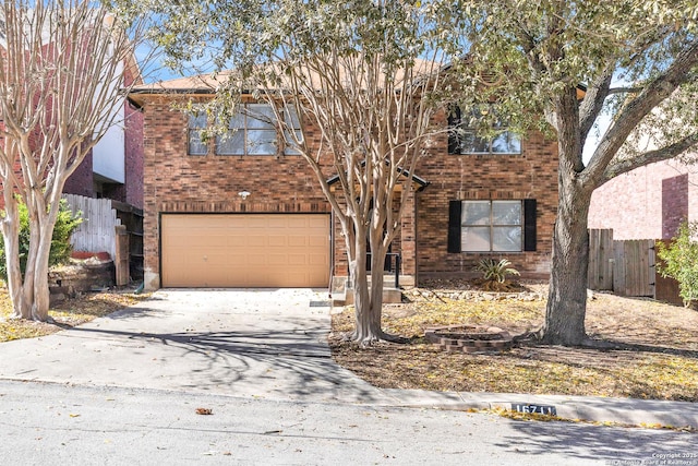 traditional home featuring brick siding, driveway, a garage, and fence