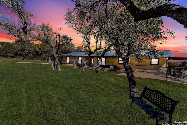 view of front of house with a front yard and a patio area