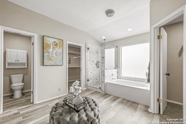 bathroom featuring a marble finish shower, a garden tub, wood finished floors, and vaulted ceiling