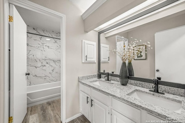 full bath with double vanity, shower / tub combination, wood finished floors, and a sink