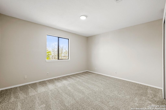 spare room with baseboards and carpet floors