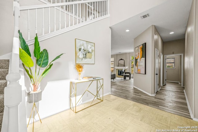 corridor with tile patterned floors, visible vents, recessed lighting, baseboards, and stairs