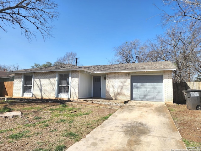 ranch-style house featuring fence, driveway, an attached garage, a shingled roof, and brick siding