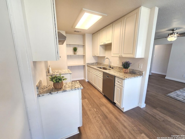 kitchen with dishwasher, light stone counters, wood finished floors, white cabinetry, and a sink