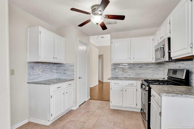 kitchen with white cabinetry, light stone countertops, visible vents, and appliances with stainless steel finishes