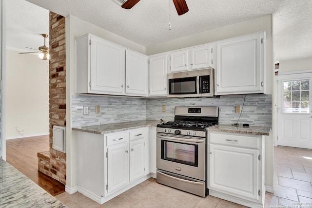 kitchen featuring white cabinets, backsplash, appliances with stainless steel finishes, and a textured ceiling