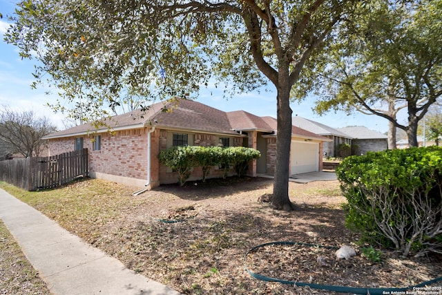 ranch-style house with concrete driveway, an attached garage, fence, and brick siding