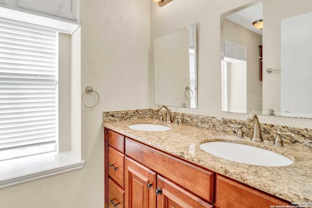 bathroom with a sink and double vanity